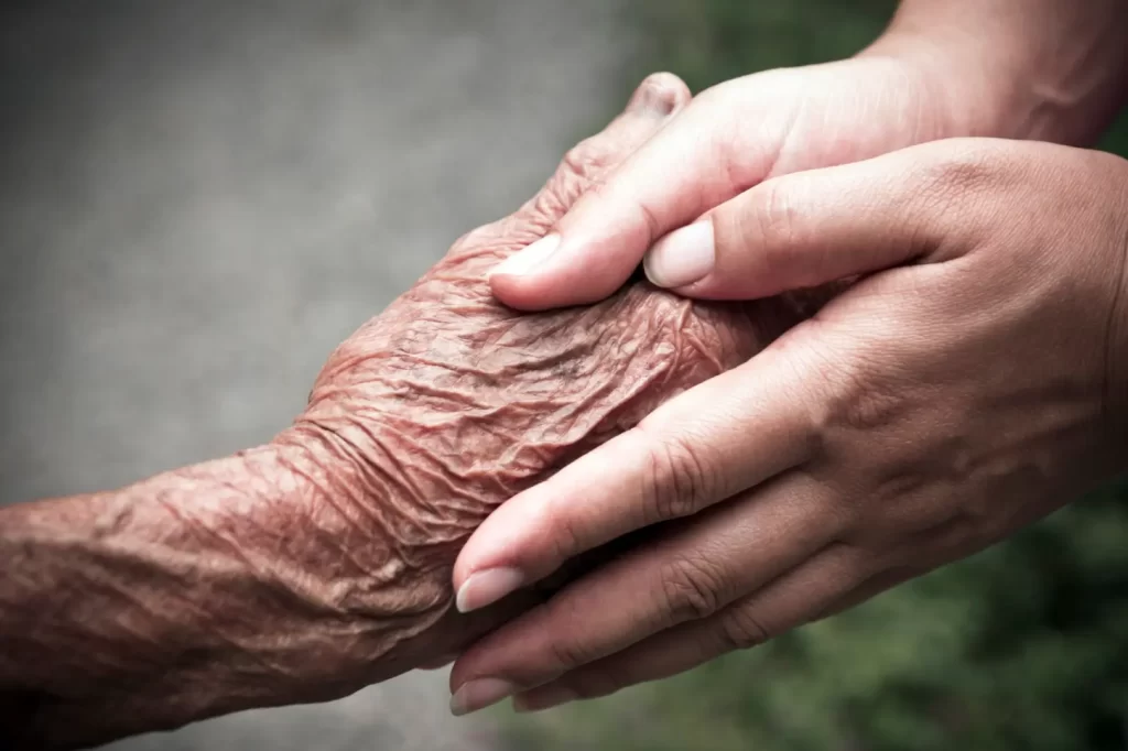 caregiver holding hands of a senior